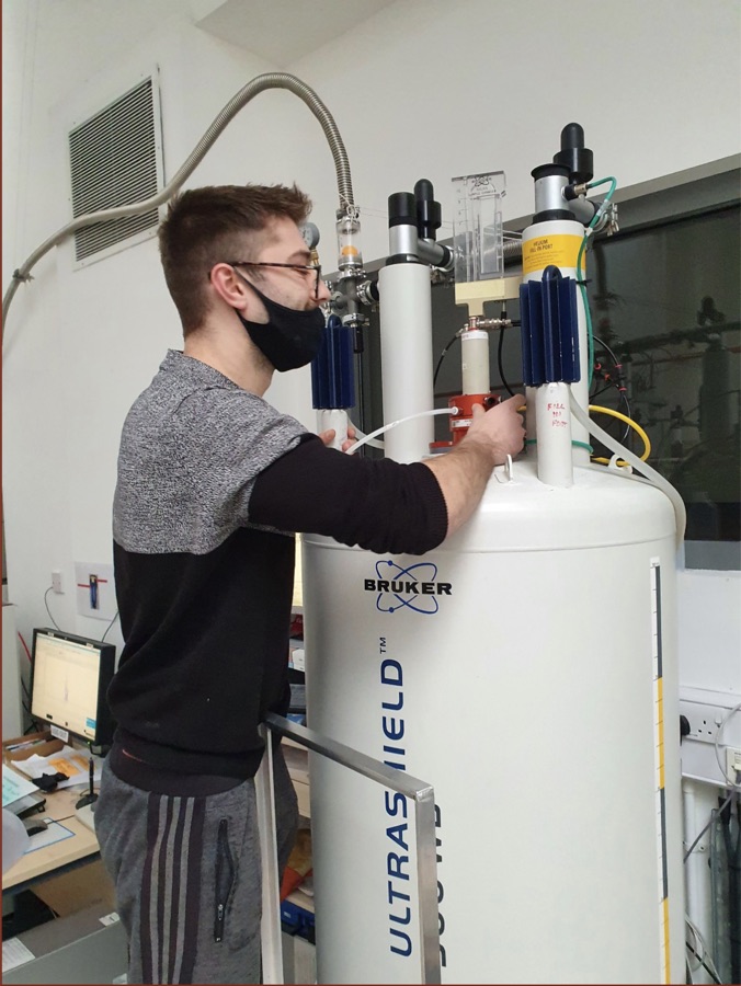 Panos Kolyvakis working at a Bruker NMR spectrometer in a university lab